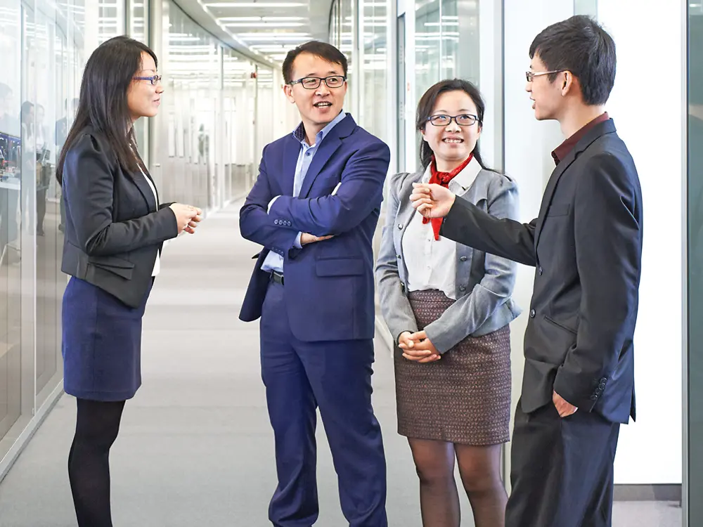 Asian employees in a hallway.